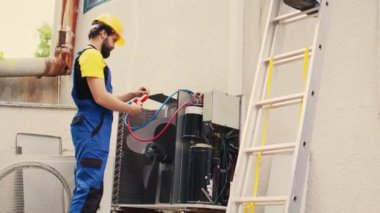 Çatı hvac sistemi iş arkadaşı, freon seviyelerini kontrol etmek için manifold göstergelerini birleştirir..