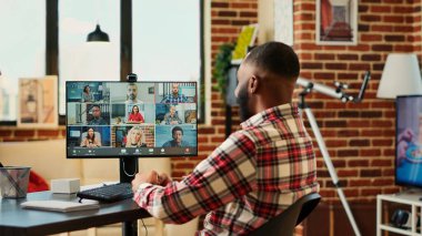 Neşeli yöneticiler uzaktan çalışan uluslararası bir ekiple görüntülü toplantı yapıyor. Şık bir karşılama dairesinde çalışan tele-sekreter çevrimiçi video görüşmesi sırasında iş arkadaşlarıyla konuşuyor.