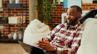 Psikologla çevrimiçi danışmanlık yapan bir hasta, çevrimiçi toplantı oturumunda tavsiye istiyor, sıcak sıcak bir evde oturuyor. Terapistle rahatlatıcı video görüşmesi yapan adam.