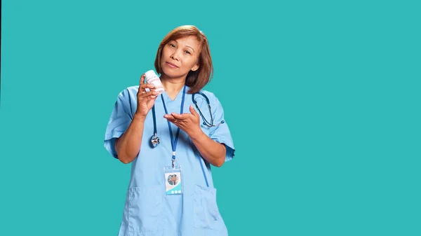 Specjalista Opieki Zdrowotnej Trzymający Butelkę Tabletkami Serce Oferujący Pomoc Medyczną — Zdjęcie stockowe