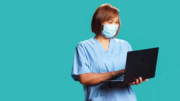 간호사가 온라인 검진을 노트북으로 환자와 수다를 있습니다 전문가는 마스크를 착용하고 — 스톡 사진