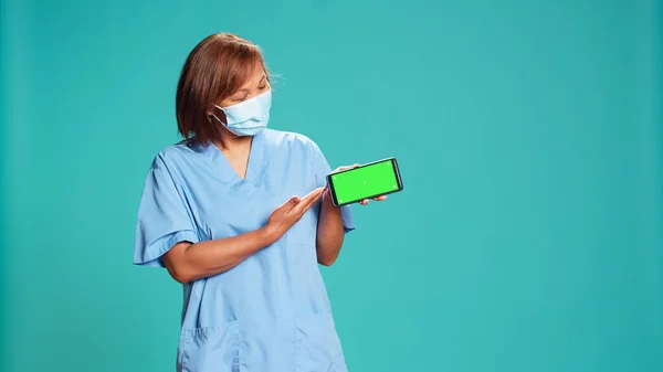 설명하는 영상을 간호사가 화면을 흉내내고 있습니다 모드로 핸드폰을 비디오를 스튜디오 — 스톡 사진