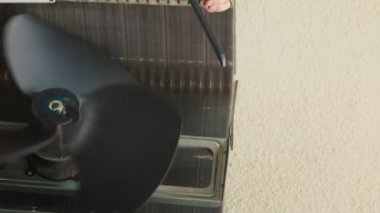 Yeni havalandırma vantilatörünü bulmak için tablet kullanan dikey video bilgisi uzmanı, ev sahibinin görevlendirildiği sırada çalışan havalandırma bileşenini arızalı bulduktan sonra çevrimiçi olarak yeni havalandırma vantilatörünü arıyor.