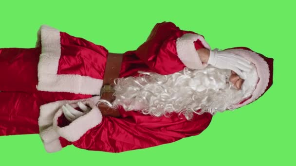 垂直ビデオグリーンスクリーンを背景にスタジオに立って痛みを伴う頭痛と父のクリスマスのフロントビュー 聖人ニック赤のスーツでUnwell男 病気お祝いの文字とともに片頭痛の感情が痛い — ストック動画