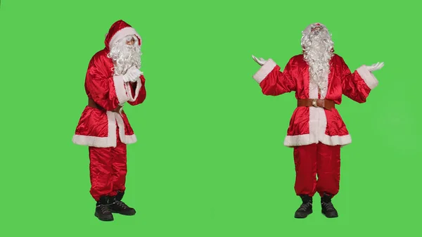 圣诞老人用双手向上帝祈祷 在工作室的全身绿屏上做着祈祷 身穿节日红衣的宗教精神人物 与耶稣谈话 为圣诞节做广告 — 图库照片