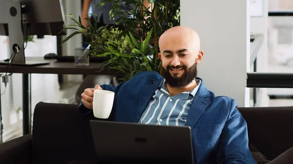 Focused consultant reading data online with archived reports and information, using laptop for startup growth. Office employee trying to find business solution in coworking space.