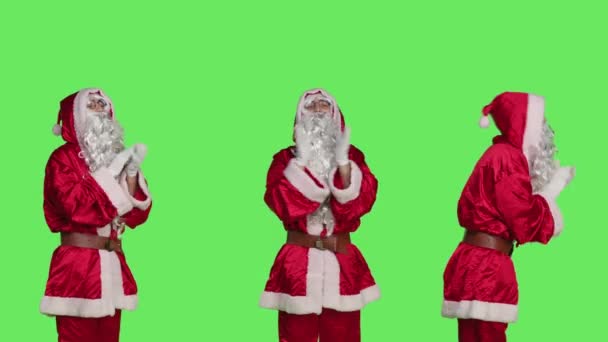 愉快的圣徒尼克拍手 为某人欢呼 在绿屏的背景下欢呼 打扮成圣诞老人的年轻人做着站着庆祝的姿势 参加节日活动 — 图库视频影像