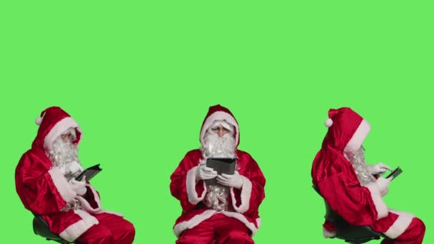 Father Christmas Uses Tablet Chair Browsing Something Online Celebrating Festive — Stock Video
