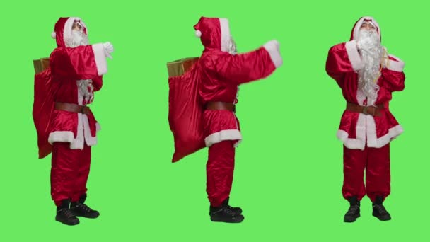 負のサンタは クリスマスの前夜の贈り物と袋を運ぶ 全身の緑の画面上に意見の相違を表現する親指を示しています 不満を持つ男は不承認のジェスチャーを嫌う — ストック動画