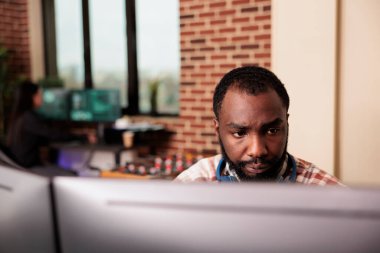 Yazılım geliştiricisi çevrimiçi bulut hesaplama bilgisini geliştirmek için bilgisayarda javascript kodu yazıyor. Afrikalı Amerikalı teknoloji mühendisi Html senaryo ve veri algoritması yazıyor, ofisinde çalışıyor.