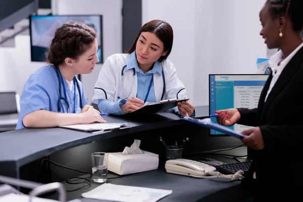 Medicinsk Personal Står Vid Receptionen Disken Diskuterar Patientsymtom Samtidigt Kontrollera — Stockfoto