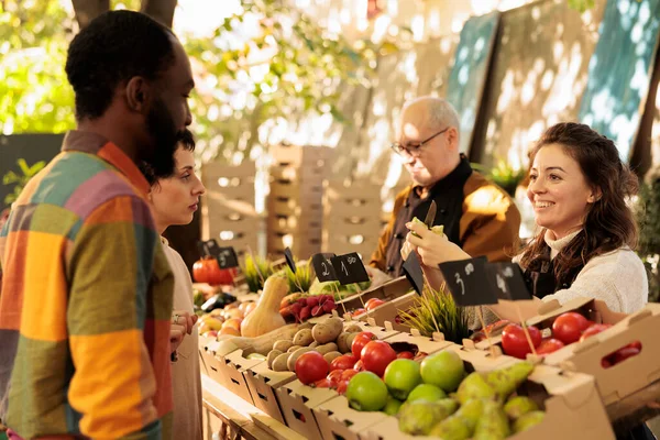 年轻的多种族夫妇男女在农贸市场购买新鲜的有机产品 微笑站在蔬果摊后面的当地女摊贩 为顾客提供苹果 — 图库照片