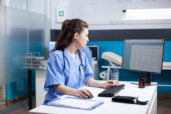 Kaukasische Krankenschwester Die Schreibtisch Arbeitet Und Daten Die Terminliste Einfügt — Stockfoto