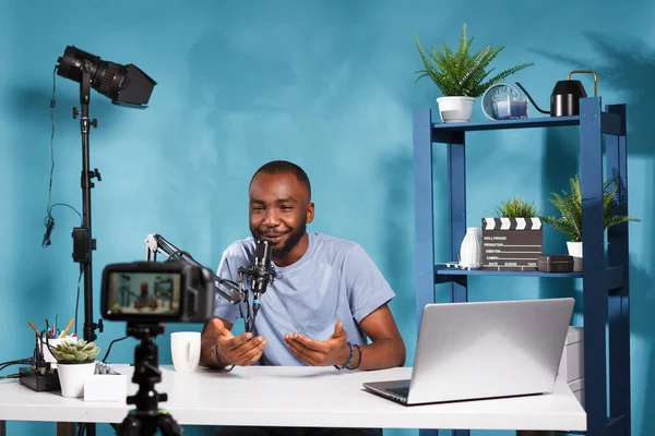 ソーシャルメディアチャンネルでのライブストリーミングにカメラとマイクを使用してブロガー スタジオでプロ仕様の機器でデジタルコンテンツを作成するアフリカ系アメリカ人のビデオVlogger — ストック写真
