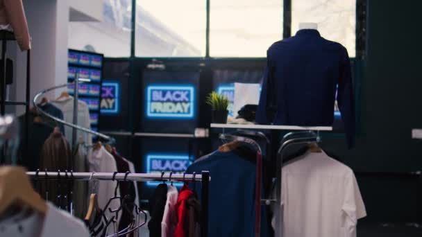 衣料品店で黒い金曜日のプロモーションサイン 現代的なファッションブティックでの季節割引 大規模な販売を宣伝するネオンバナー 小売店センターでの特別な11月のオファー — ストック動画