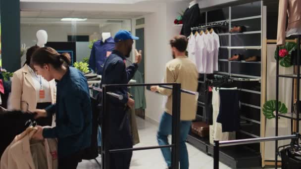 ショッピングセンターのブラックフライデーの強迫観念 顧客は 割引アイテムを購入するためにハンガーやラックからすべての服をつかむ 小売店に夢中になっている人たちの大群衆 トリポッドショット — ストック動画