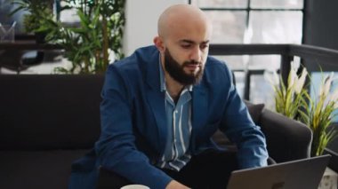 Ortadoğulu adam ofiste profesyonel pazarlama raporu oluşturmadan önce internetten belge okuyor. İş çözümünü bulmaya çalışan erkek işçi, birlikte çalışma alanında girişimci.