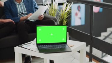 Laptop, küçük işletme ortak çalışma ofisinde yeşil ekran şablonu gösteriyor, masadaki izole bir telif alanı görüntüsü. Ekranda boş kromakey yazılım, profesyonel yürütme kuruluşu.