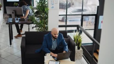 Specialist analyzing strategy data and trying to create new investment for small business development. Middle eastern businessman working in open space, marketing department executive job.