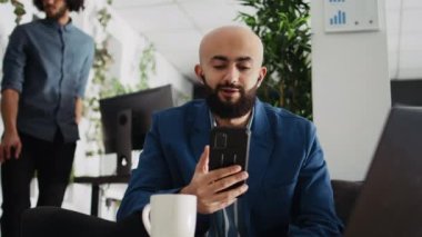 İş adamı online video konferansında, yönetim kuruluyla brifing hakkında konuşuyor. Ortadoğu bürosu çalışanı cep telefonuyla tele-iş görüşmesi yapıyor. Üçayak atışı.