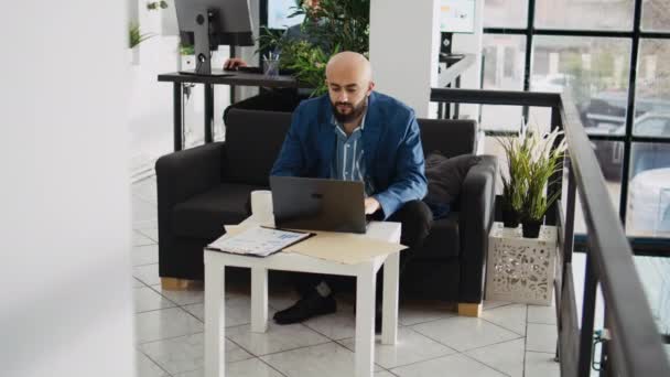 オフィスの中東の従業員 仕事を解決するためにラップトップで働く専門のコンサルタント 会社のマネージャーは公式文書を読み プログラミング統計データ 起業家精神 — ストック動画