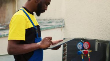 Büyük bozulmaları önlemek için soğutucu seviyelerini ve gerekli onarımları denetleyen uzman bir tamirci. Profesyonel işçi sorun giderici, bulguları panoya yazma