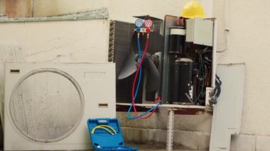 Bozuk dış havalandırma ünitesinin yakın çekim görüntüsüne yakınlaş. Korunma kapağı kaldırılmalı ve tamir edilmeli. Hasarlı elektrik bileşenleri ve hatalı kablolarla.