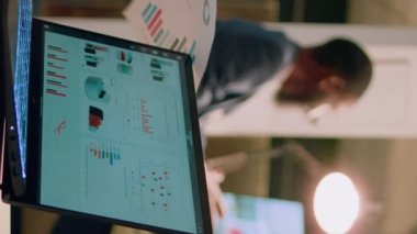 Asistanı gerekli evrakları hazırlarken, Dikey Video Yöneticisi iş arkadaşlarıyla çevrimiçi telekonferans toplantısı düzenliyor. Yönetim yöneticisi video çağrısında çalışanlarla sohbet ediyor