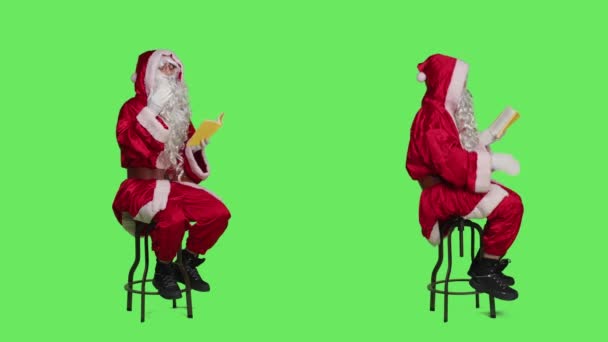 Батько Різдва Читає Літературу Студії Повноцінним Зеленим Кольором Тіла Насолоджуючись — стокове відео