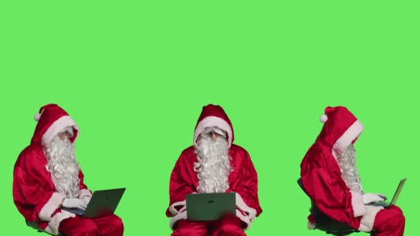 Modern Santa Claus Dolgozik Laptop Zöldvászon Háttér Stúdió Mikulás Széken — Stock videók
