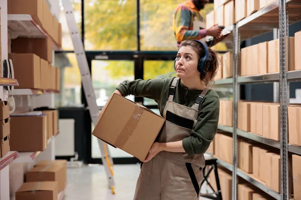 Storage Room Manager Looking Shelves Full Boxes Wearing Headphones Listening — Stock Photo, Image
