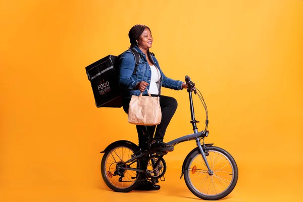 Afrikai Amerikai Kézbesítő Papírzacskóval Kezében Miközben Ebédrendelést Szállít Ügyfélnek Biciklit — Stock Fotó