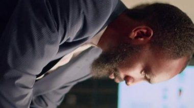 Dikey video Afrikalı Amerikalı muhasebeci iş yerinde konsantre olmaya çalışıyor çünkü iş arkadaşı müzik dinlerken çok gürültü yapıyor. İş arkadaşından rahatsız olmuş taklidini yaparken çok ses çıkarıyor.