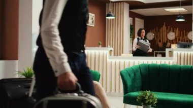 Tatilde rahat, neşeli turist şık bir otel girişinde bekliyor. Keyifli turist rahat bir dinlenme odasında oturuyor, balo çocuğu valizini taşırken otel odası verilmeye hazır.