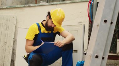 Klima bakımı ve iç organları kontrol etmesi için ev sahibi tarafından görevlendirilmiş profesyonel bir işçi. Uzman tamirci, ihtiyaç duyulan yeni bileşenlerin maliyetini not alıyor.