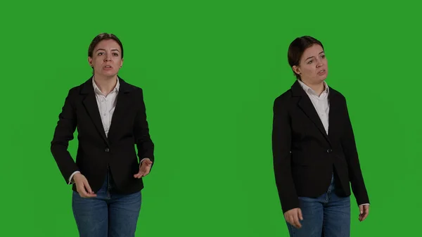 若い怒っている実業家負とカメラに激怒演技 緑の背景の上に立っている 女性従業員が対立し スタジオで意見の不一致や不承認を表明 — ストック写真