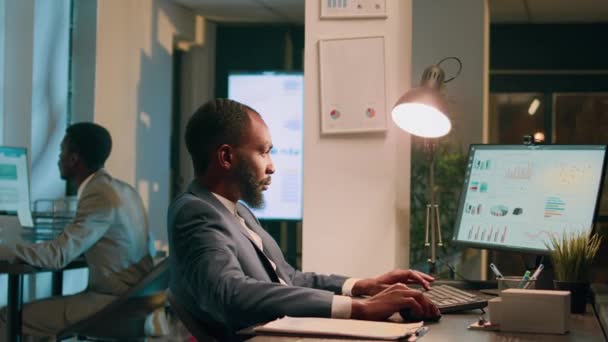 Afroamerikanische Geschäftsleute Sitzen Schreibtisch Schauen Über Finanzdiagramme Und Schreiben Während — Stockvideo