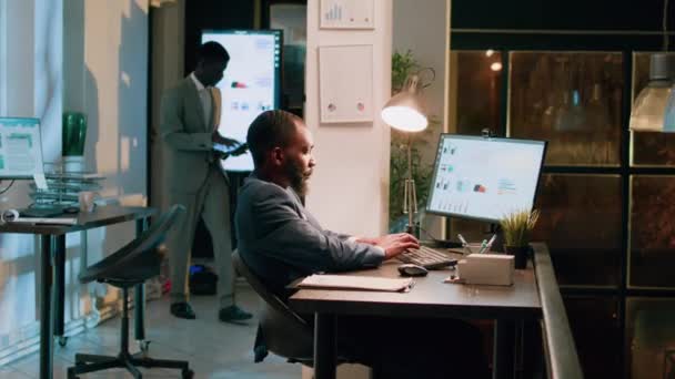 在笔记本电脑上显示助理项目结果的业务管理员 在夜班时交叉查找财务信息 在现代办公室工作一夜的公司职员 — 图库视频影像
