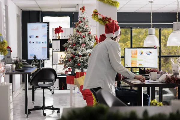 从事现代办公室营业收入统计表工作的员工都是圣诞装饰品 穿着节日节日服装的同事为营销项目做研究 — 图库照片