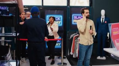 Haber muhabiri, Kara Cuma satışları sırasında mağazadan canlı yayın yapıyor televizyon ve medya için yayın yapıyor. Meşgul alışveriş merkezinde mikrofon kullanan gazeteci.