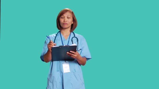 Επαγγελματική Νοσηλεύτρια Γράφει Λίστα Ραντεβού Των Επερχόμενων Ασθενών Στο Πρόχειρο — Αρχείο Βίντεο