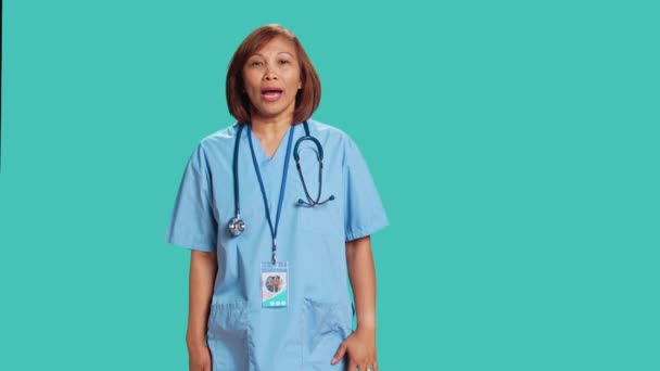 전문가들은 직장에서 격렬하고 공격적으로 몸짓을 겁먹은 이시아인 간호사 스튜디오 배경에서 — 비디오