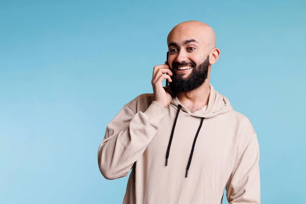 快乐的阿拉伯人 一边用智能手机聊天 一边微笑 在手机上聊天的人和听谈话的人 脸上带着兴奋的表情 — 图库照片