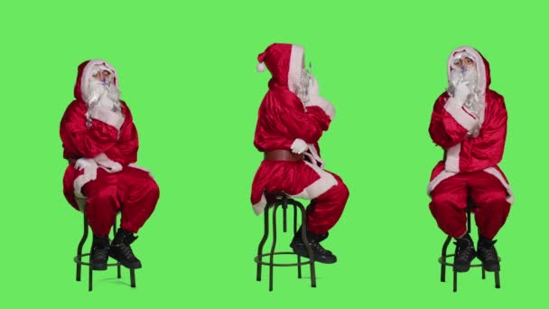 穿着红色服装的角色坐在椅子上 在全身上下的绿屏背景上思考着新的想法 年轻的苦思冥想者 穿着西服 留着白胡子 头脑清醒 — 图库视频影像