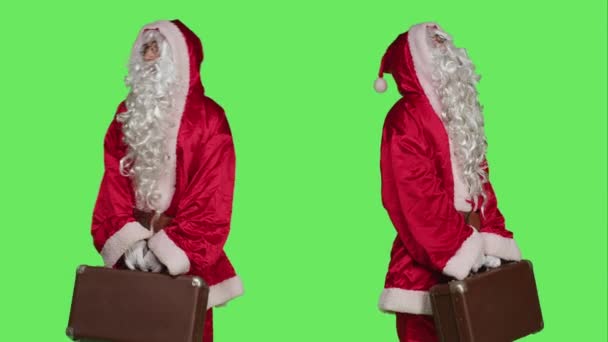 Vrolijke Man Kerstman Kostuum Houden Koffer Wachten Iets Studio Met — Stockvideo