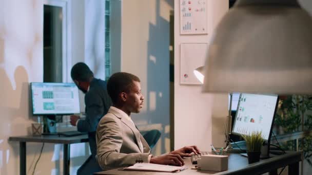 非裔美国人经理要求员工在上夜班时向他展示公司项目任务的进展情况 管理层对工作中的文件进行交叉审查 — 图库视频影像