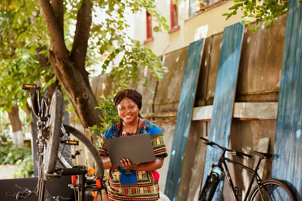 Enthusiastic Sports Loving African American Female Laptop Repairing Bicycle Home — Stock Photo, Image