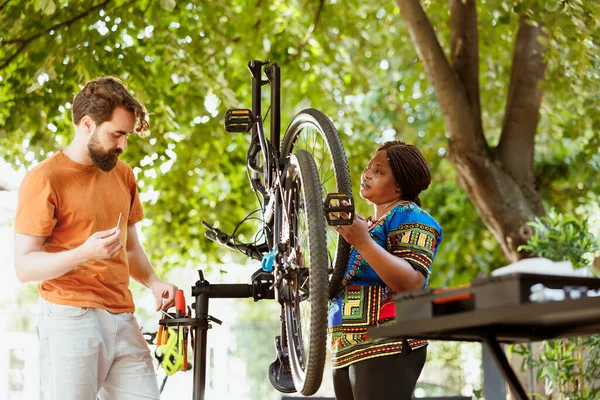 Multiracial Girlfriend Boyfriend Using Professional Equipment Fix Broken Bike Tire — Stock Photo, Image