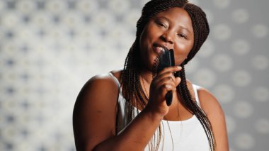 Flawless elegant lady singing with hair brush on camera and showing self love, embracing imperfections in skincare ad campaign. Beautiful woman feeling sensual and funny, promoting self confidence.