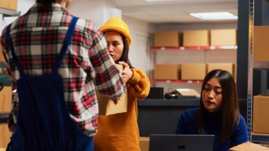 Sipariş yönetimi için ürün göndermek üzere paketlerdeki malları kontrol eden bir grup işçi. Depodaki küçük işletmeler için finansal planlama yapmak için takım halinde çalışan Asyalılar. El kamerasıyla..